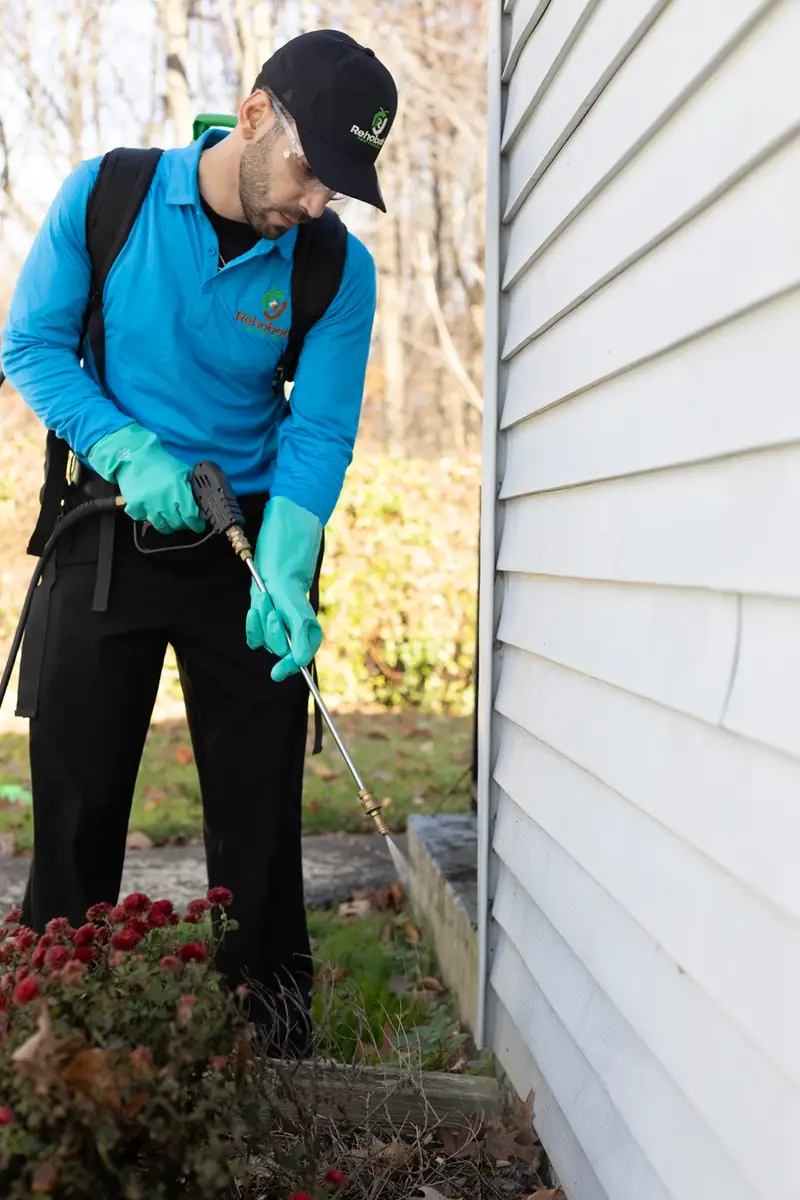Technician treating along a home's foundation