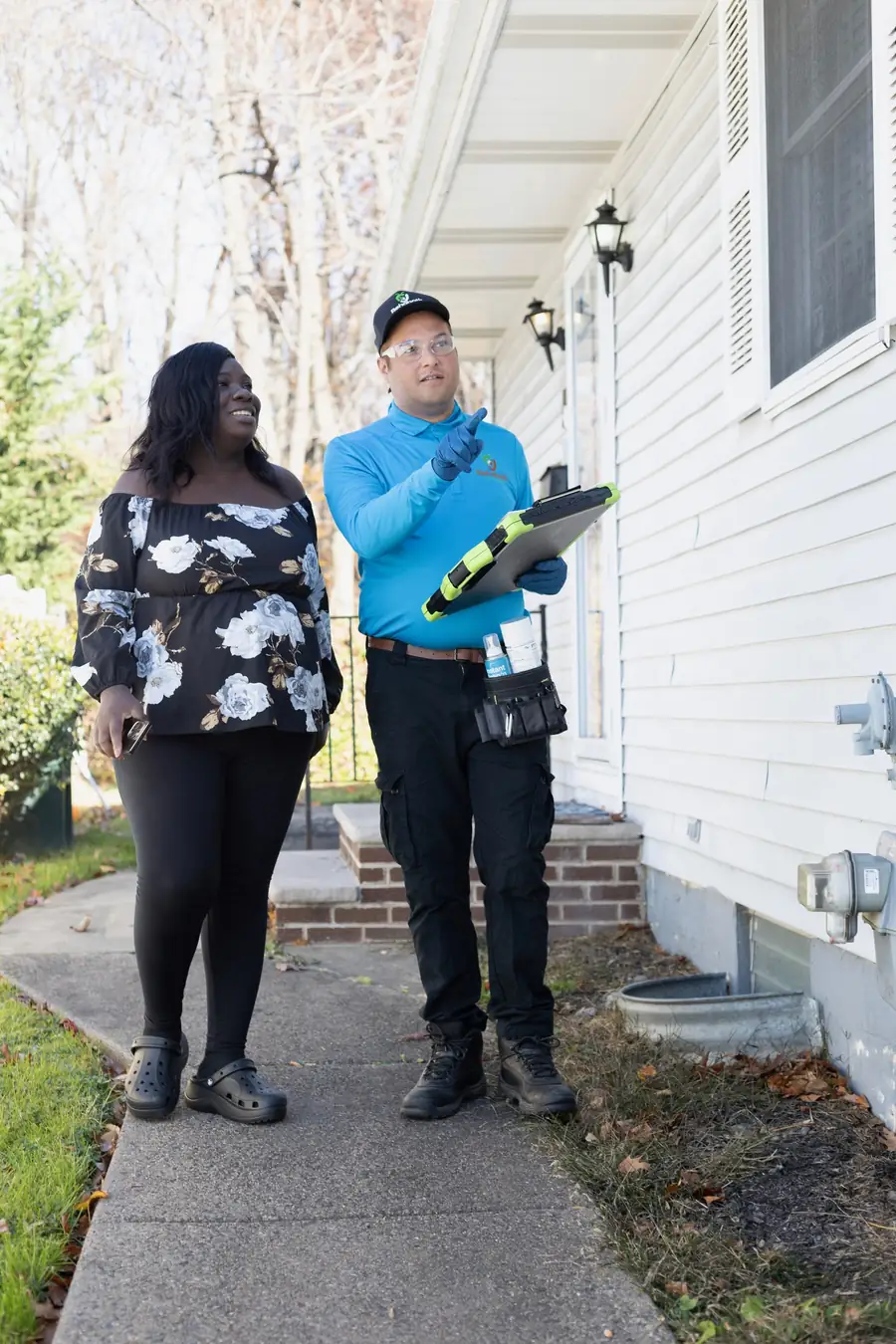 Technician pointing out entry points to a homeowner during an inspection